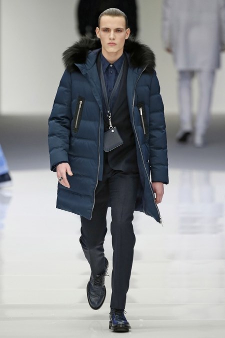 Model z pokazu Versace w granatowej kurtce puchowej z futerkowym akcentem na kapturze.