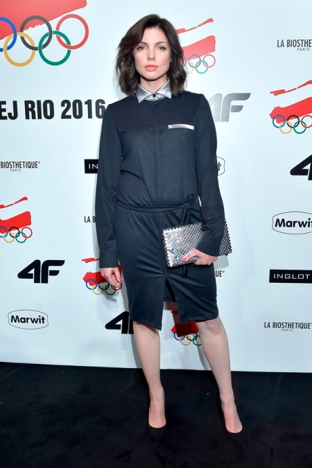 Karolina Gorczyca w eleganckiej czarnej sukience z kołnierzem.