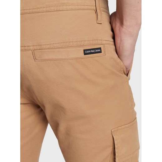 Calvin Klein Jeans Spodnie materiałowe J30J322043 Beżowy Regular Fit 33 okazyjna cena MODIVO