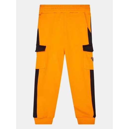 Guess Spodnie dresowe L3YQ12 KA6R3 Pomarańczowy Regular Fit ze sklepu MODIVO w kategorii Spodnie chłopięce - zdjęcie 168445003