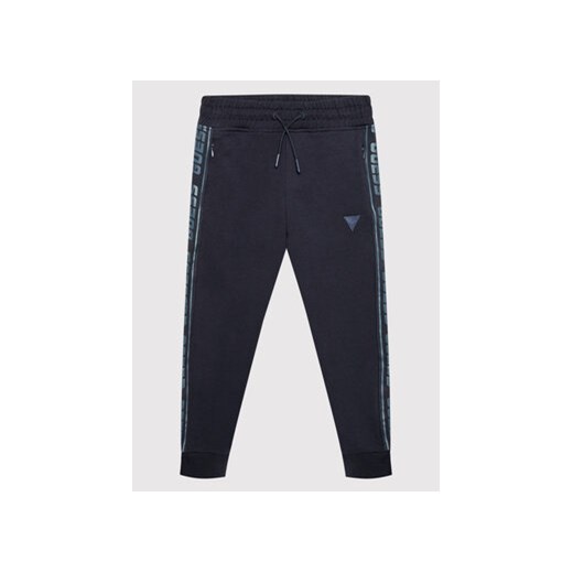 Guess Spodnie dresowe L2YQ48 K6ZS1 Granatowy Regular Fit ze sklepu MODIVO w kategorii Spodnie chłopięce - zdjęcie 168582131