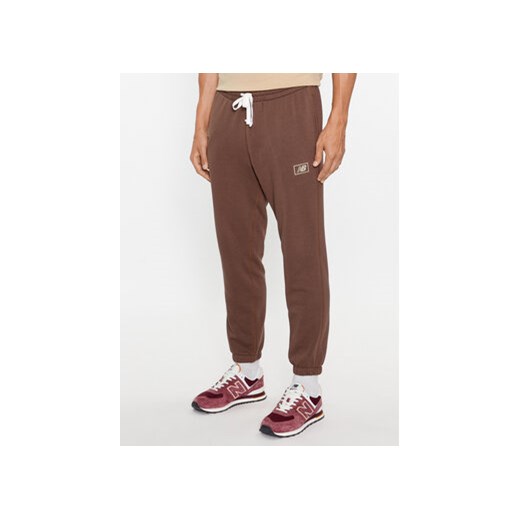 New Balance Spodnie dresowe NB Essentials Sweatpant MP33509 Brązowy Regular Fit ze sklepu MODIVO w kategorii Spodnie męskie - zdjęcie 168613813
