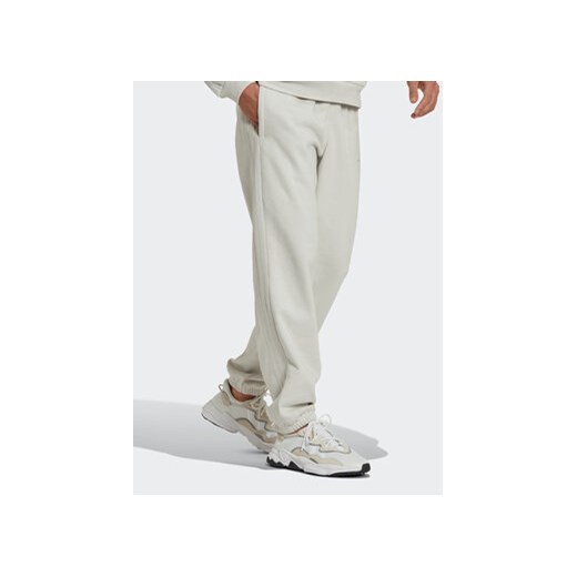 adidas Spodnie dresowe Reveal Essentials HK2728 Beżowy Regular Fit ze sklepu MODIVO w kategorii Spodnie męskie - zdjęcie 168734544