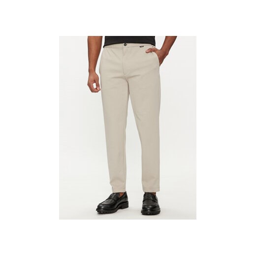 Calvin Klein Spodnie materiałowe K10K113647 Beżowy Comfort Fit ze sklepu MODIVO w kategorii Spodnie męskie - zdjęcie 169501153