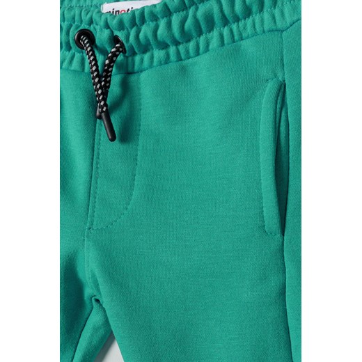 Zielone spodnie dresowe niemowlęce z białymi paskami Minoti 86/92 5.10.15