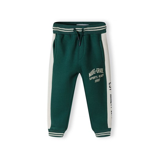 Spodnie dresowe dla chłopca z bocznymi panelami - butelkowa zieleń ze sklepu 5.10.15 w kategorii Spodnie chłopięce - zdjęcie 169724354