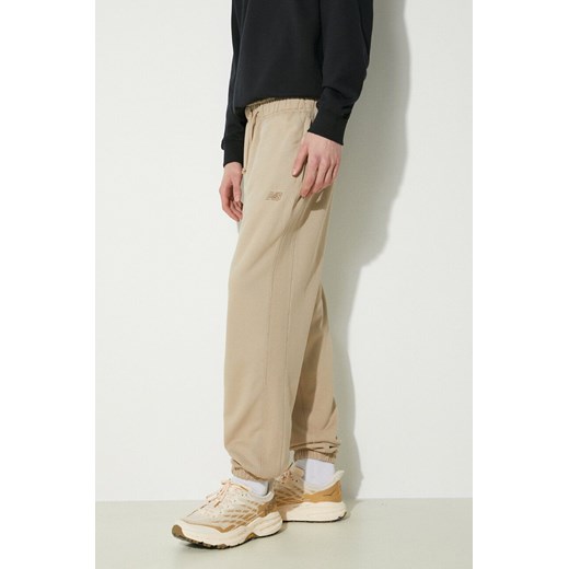 New Balance spodnie dresowe bawełniane MP41508SOT kolor beżowy gładkie ze sklepu PRM w kategorii Spodnie męskie - zdjęcie 170264251