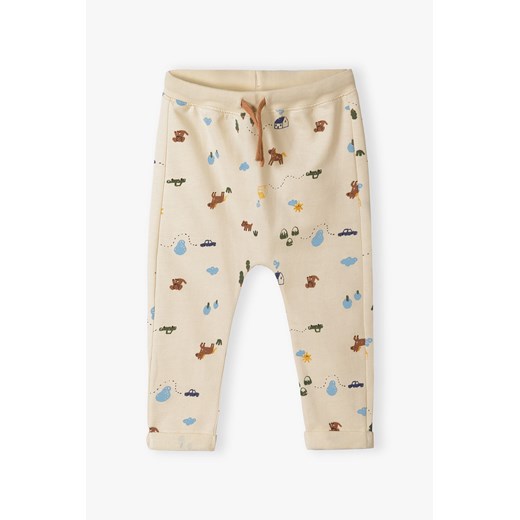 Beżowe bawełniane spodnie dresowe niemowlęce z nadrukiem ze sklepu 5.10.15 w kategorii Spodnie i półśpiochy - zdjęcie 170492960