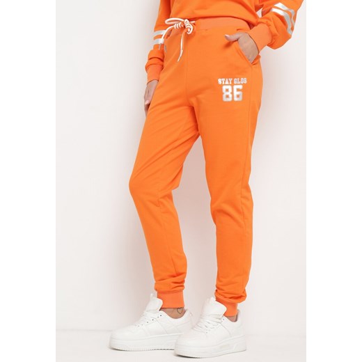 Pomarańczowe Spodnie Dresowe z Wiązaniem w Pasie i Ozdobnym Nadrukiem Sacaria ze sklepu Born2be Odzież w kategorii Spodnie damskie - zdjęcie 170642752