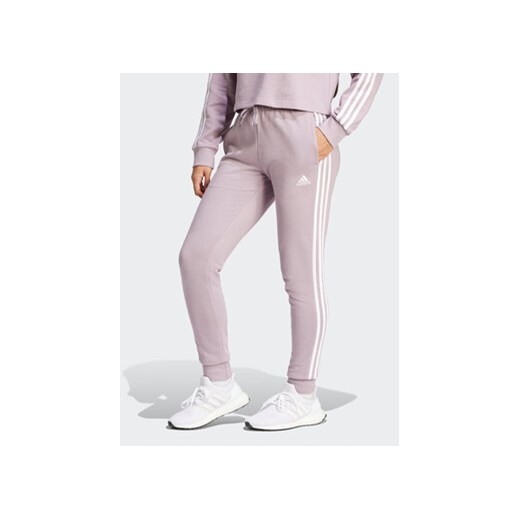 adidas Spodnie dresowe Essentials 3-Stripes IR5379 Różowy Slim Fit ze sklepu MODIVO w kategorii Spodnie damskie - zdjęcie 171377722