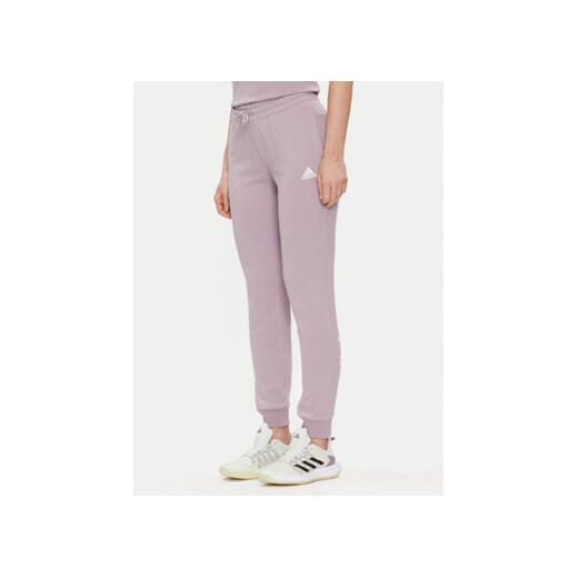 adidas Spodnie dresowe Essentials Linear IS2105 Fioletowy Slim Fit ze sklepu MODIVO w kategorii Spodnie damskie - zdjęcie 171517412