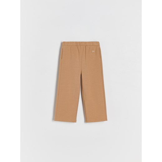 Reserved - Bawełniane spodnie z naszywką - beżowy ze sklepu Reserved w kategorii Spodnie dziewczęce - zdjęcie 176366792