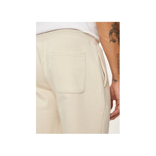 Tommy Jeans Spodnie dresowe Flag DM0DM20473 Beżowy Slim Fit Tommy Jeans XXL MODIVO