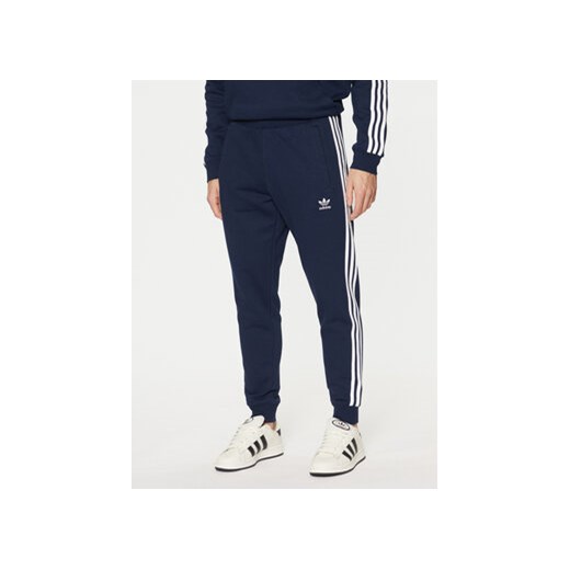 adidas Spodnie dresowe adicolor 3-Stripes IM9319 Granatowy Slim Fit ze sklepu MODIVO w kategorii Spodnie męskie - zdjęcie 177026754
