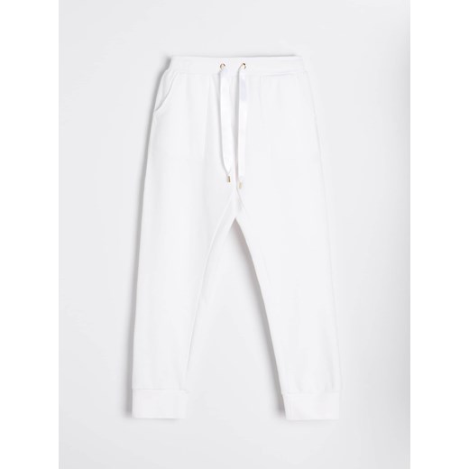 Sinsay - Eleganckie spodnie dresowe z ozdobnym wiązaniem - kremowy Sinsay XS Sinsay