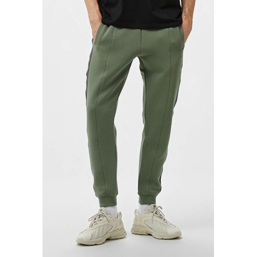 GUESS Zielone męskie spodnie dresowe z lampasami Mickey, Rozmiar S ze sklepu outfit.pl w kategorii Spodnie męskie - zdjęcie 179276120