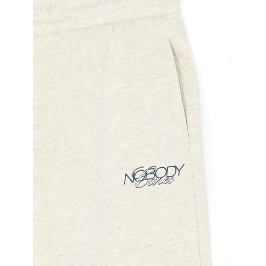 Cropp - Melanżowe kremowe spodnie z nadrukiem - kremowy Cropp XL Cropp