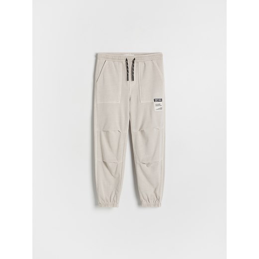 Reserved - Joggery z efektem sprania - beżowy Reserved 122 (6-7 lat) Reserved
