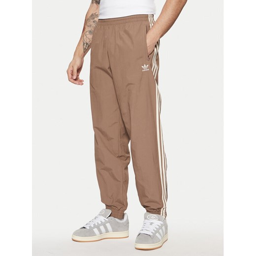 adidas Spodnie dresowe adicolor Firebird JP1024 Beżowy Regular Fit ze sklepu MODIVO w kategorii Spodnie męskie - zdjęcie 182595640