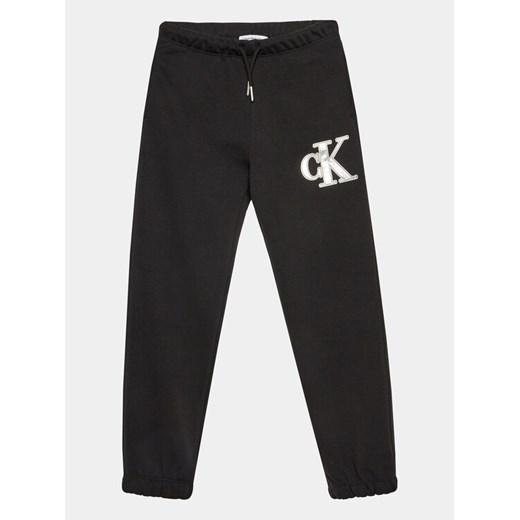 Calvin Klein Jeans Spodnie dresowe Metallic IG0IG02287 Czarny Regular Fit ze sklepu MODIVO w kategorii Spodnie chłopięce - zdjęcie 182596182