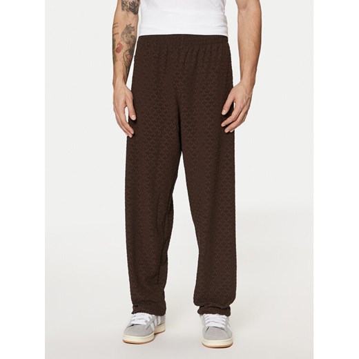 adidas Spodnie dresowe Monogram Track JP4428 Brązowy Regular Fit ze sklepu MODIVO w kategorii Spodnie męskie - zdjęcie 182599991