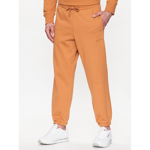 New Balance Spodnie dresowe MP23551 Pomarańczowy Relaxed Fit ze sklepu MODIVO w kategorii Spodnie męskie - zdjęcie 182601524