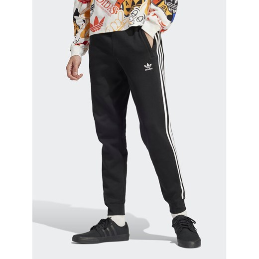adidas Spodnie dresowe adicolor 3-Stripes IU2353 Czarny Slim Fit ze sklepu MODIVO w kategorii Spodnie męskie - zdjęcie 182606371