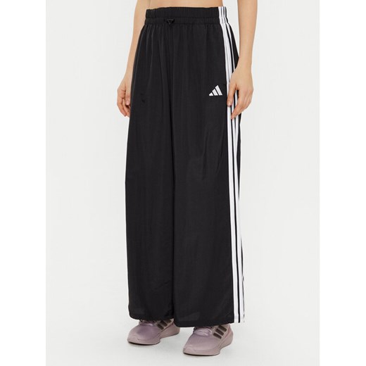 adidas Spodnie dresowe Essentials 3-Stripes JE1306 Czarny Loose Fit ze sklepu MODIVO w kategorii Spodnie damskie - zdjęcie 182613080