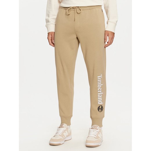 Timberland Spodnie dresowe TB0A5YFBDH41 Beżowy Regular Fit ze sklepu MODIVO w kategorii Spodnie męskie - zdjęcie 182623250
