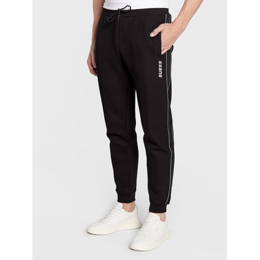 Guess Spodnie dresowe Mickey Z2YB09 KB3P2 Czarny Regular Fit ze sklepu MODIVO w kategorii Spodnie męskie - zdjęcie 182634932