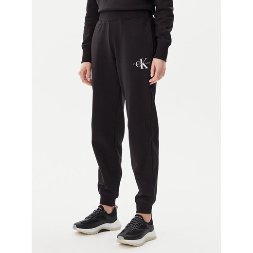 Calvin Klein Jeans Spodnie dresowe Monologo J20J225354 Czarny Slim Fit ze sklepu MODIVO w kategorii Spodnie damskie - zdjęcie 182636061