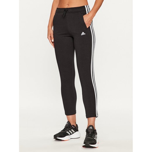 adidas Spodnie dresowe Essentials 3-Stripes IC6126 Czarny Slim Fit ze sklepu MODIVO w kategorii Spodnie dziewczęce - zdjęcie 182644282