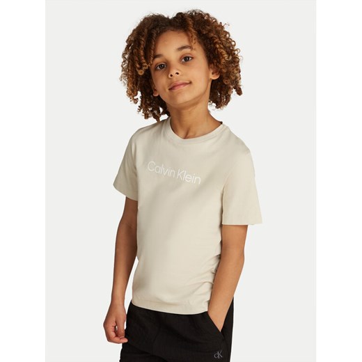 Calvin Klein Jeans T-Shirt IU0IU00682 Beżowy Regular Fit ze sklepu MODIVO w kategorii Bluzki dziewczęce - zdjęcie 182656722