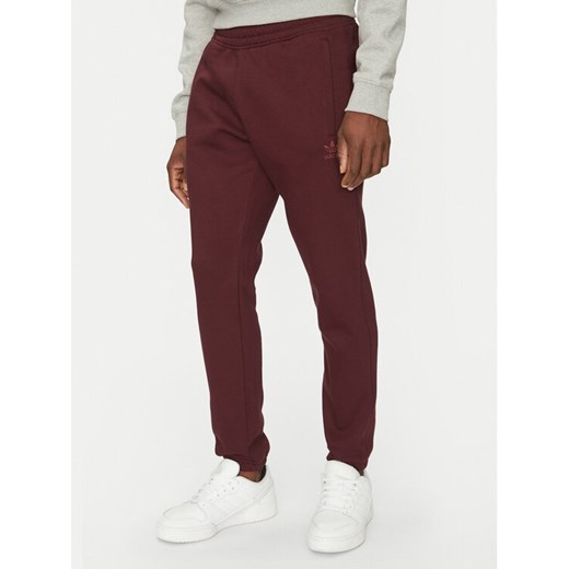 adidas Spodnie dresowe Trefoil Essentials JD2420 Bordowy Slim Fit ze sklepu MODIVO w kategorii Spodnie męskie - zdjęcie 182657210