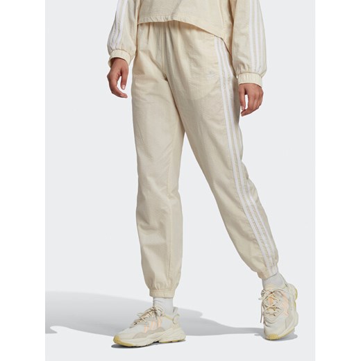 adidas Spodnie dresowe adicolor lassics Poplin Track HL9309 Écru Regular Fit ze sklepu MODIVO w kategorii Spodnie damskie - zdjęcie 182660614