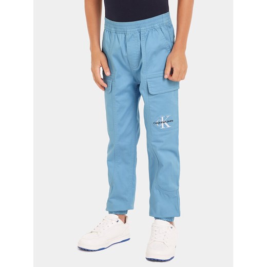 Calvin Klein Jeans Joggery IB0IB01675 Niebieski Regular Fit ze sklepu MODIVO w kategorii Spodnie chłopięce - zdjęcie 182663353