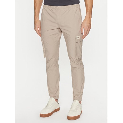 Calvin Klein Jeans Joggery J30J327614 Beżowy Skinny Fit ze sklepu MODIVO w kategorii Spodnie męskie - zdjęcie 182676010