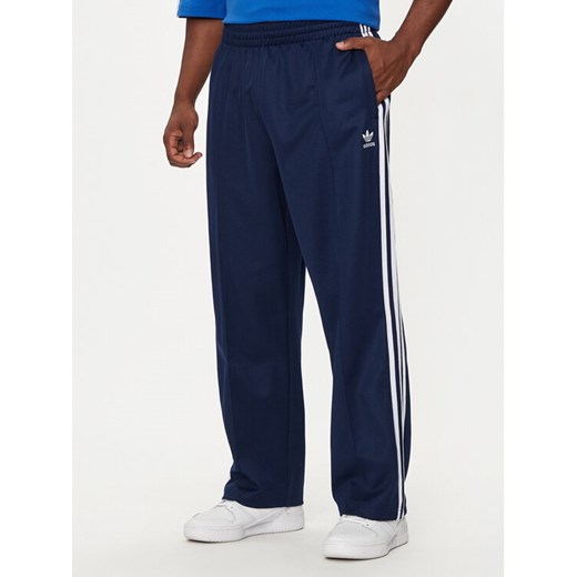 adidas Spodnie dresowe adicolor Firebird IZ2466 Granatowy Baggy Fit ze sklepu MODIVO w kategorii Spodnie męskie - zdjęcie 182678352