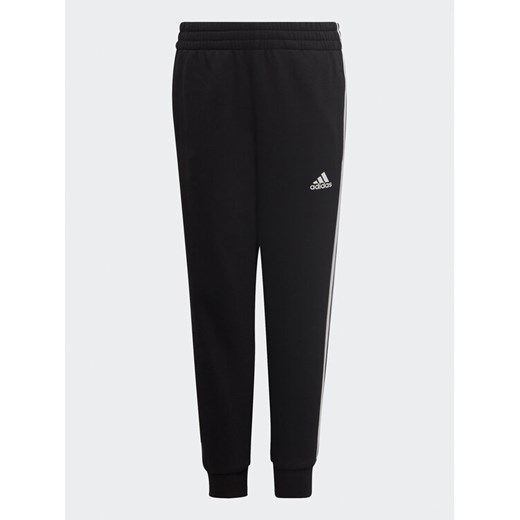 adidas Spodnie dresowe adidas Essential 3-Stripes Joggers H65796 Czarny Regular Fit ze sklepu MODIVO w kategorii Spodnie chłopięce - zdjęcie 182680353
