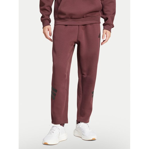 adidas Spodnie dresowe Future Icons 3-Stripes JD4888 Bordowy Loose Fit ze sklepu MODIVO w kategorii Spodnie męskie - zdjęcie 182682631