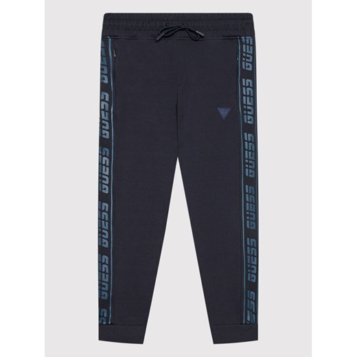 Guess Spodnie dresowe L2RQ15 K6ZS1 Granatowy Regular Fit ze sklepu MODIVO w kategorii Spodnie chłopięce - zdjęcie 182683664