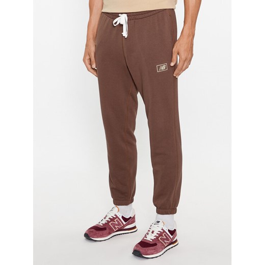 New Balance Spodnie dresowe NB Essentials Sweatpant MP33509 Brązowy Regular Fit ze sklepu MODIVO w kategorii Spodnie męskie - zdjęcie 182691353