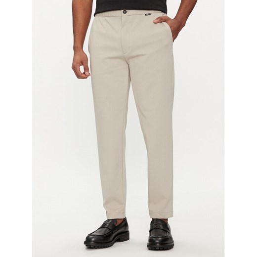 Calvin Klein Spodnie materiałowe K10K113647 Beżowy Comfort Fit ze sklepu MODIVO w kategorii Spodnie męskie - zdjęcie 182692361
