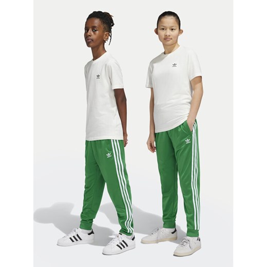 adidas Spodnie dresowe adicolor SST IY7461 Zielony Regular Fit ze sklepu MODIVO w kategorii Spodnie chłopięce - zdjęcie 182692383