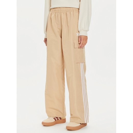 adidas Spodnie dresowe adicolor 3-Stripes IZ0717 Beżowy Loose Fit ze sklepu MODIVO w kategorii Spodnie damskie - zdjęcie 182692814