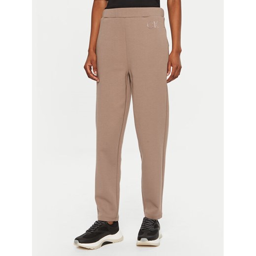 Calvin Klein Spodnie dresowe Satin K20K207945 Beżowy Slim Fit ze sklepu MODIVO w kategorii Spodnie damskie - zdjęcie 182693300
