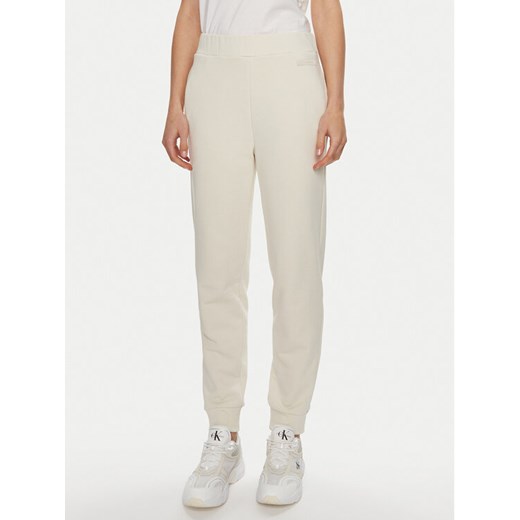 Calvin Klein Spodnie dresowe Micro Logo K20K206632 Écru Regular Fit ze sklepu MODIVO w kategorii Spodnie damskie - zdjęcie 182698933