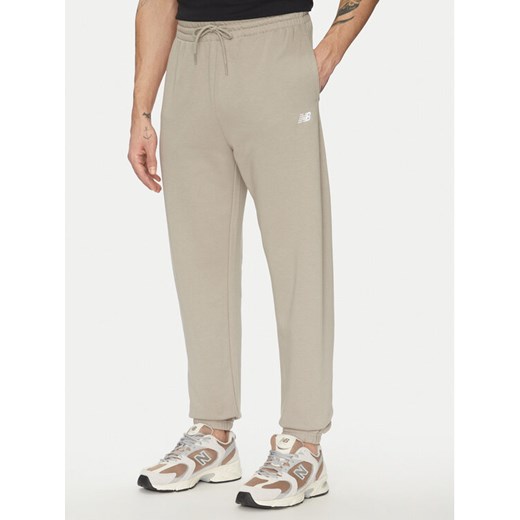 New Balance Spodnie dresowe Essentials MP41519 Beżowy Relaxed Fit ze sklepu MODIVO w kategorii Spodnie męskie - zdjęcie 182710544