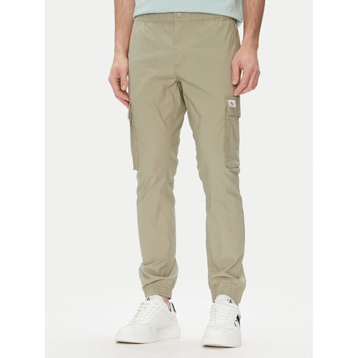Calvin Klein Jeans Joggery J30J327614 Zielony Slim Fit ze sklepu MODIVO w kategorii Spodnie męskie - zdjęcie 182726861