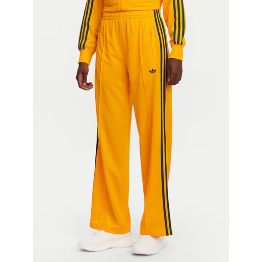 adidas Spodnie dresowe adicolor Classic Firebird JP2316 Żółty Loose Fit ze sklepu MODIVO w kategorii Spodnie damskie - zdjęcie 182728910